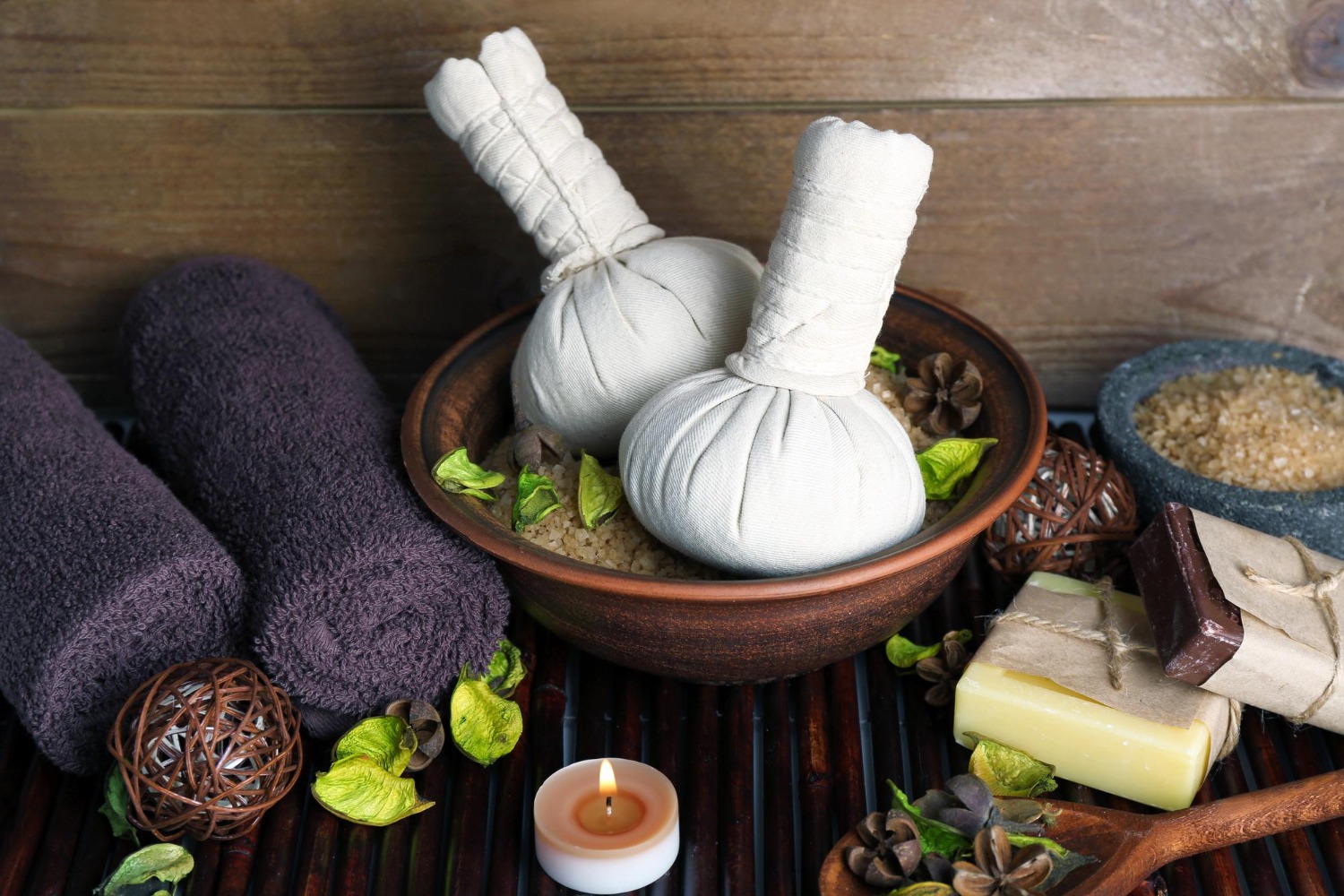Ayurvedic herbal poultices with towels and natural spa accessories